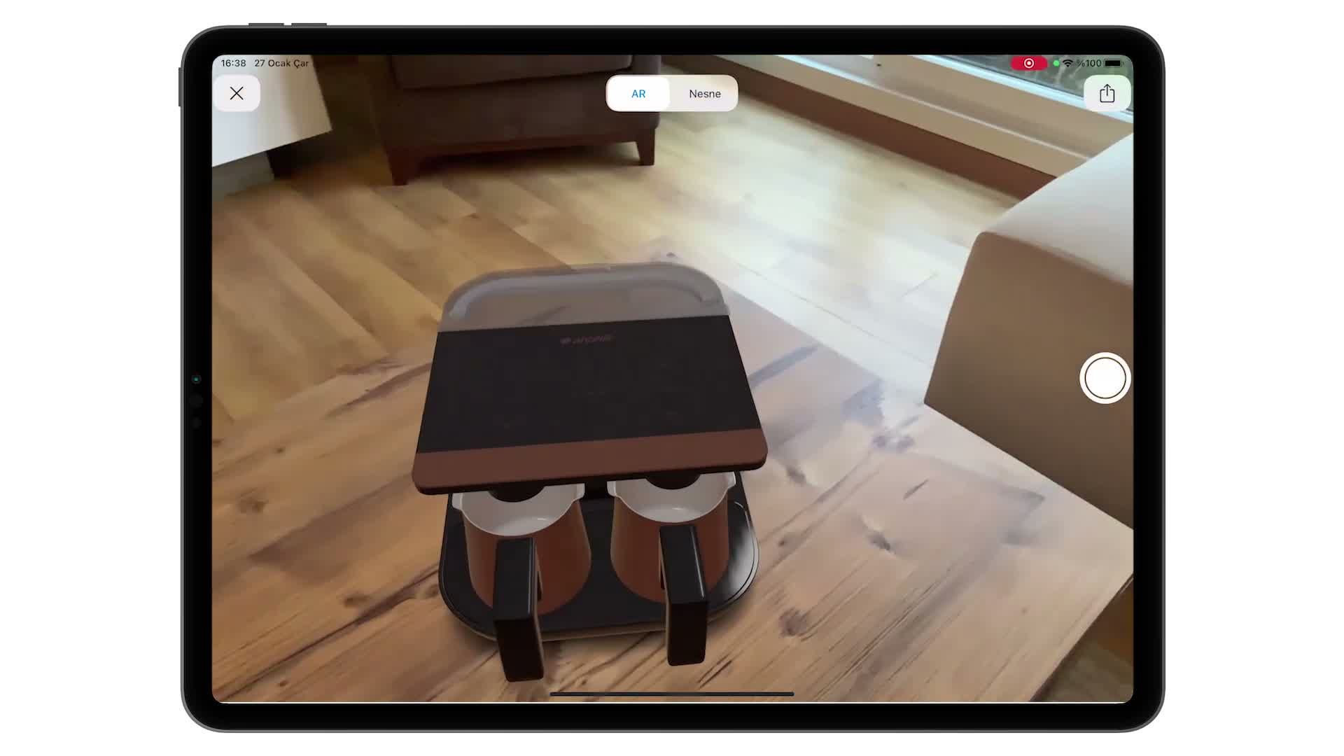 iPad ekranında, gerçek bir oturma odasına WebAR ile yerleştirilmiş 3D kahve makinesi